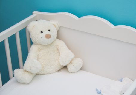 image de présentation de l'article accessoires lit bebe à ne pas oublier représentant un ourson blanc dans un lit à barreaux